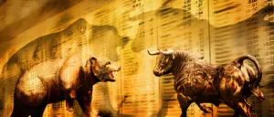A bull and bear are facing each other in front of the stock market.