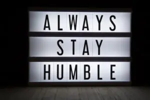 A lit up sign that says always stay humble.