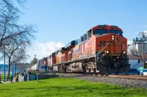 A train is traveling down the tracks near some trees.