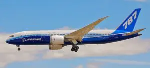 A large airplane flying in the sky with clouds