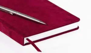 A pen and notebook on top of a table.