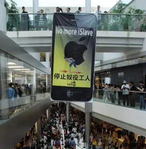 A large sign in an asian mall with people walking around.