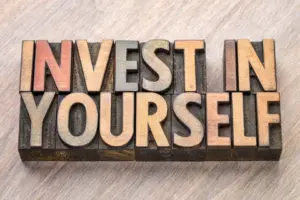 Invest in yourself written on a wooden block