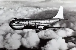 A large airplane flying through the sky above clouds.