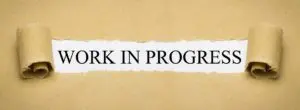 A torn piece of paper with the words work in progress written on it.