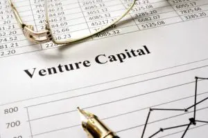 A pen and glasses sitting on top of a venture capital document.