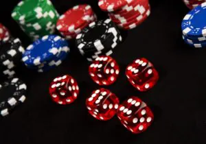 A pile of red dice sitting next to a bunch of other chips.