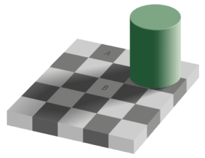 A green cylinder sitting on top of a chess board.