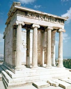 A large stone structure with pillars on top of it.