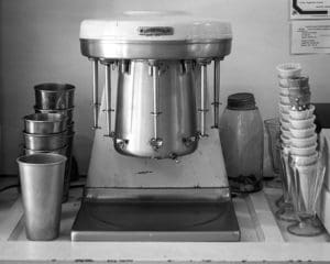 A black and white photo of a kitchen with many dishes.