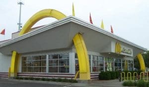 A large yellow banana shaped building with two red and white flags.