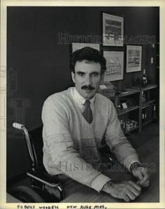 A man sitting in a chair wearing a tie.