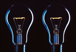 Two light bulbs are lit up in the dark.
